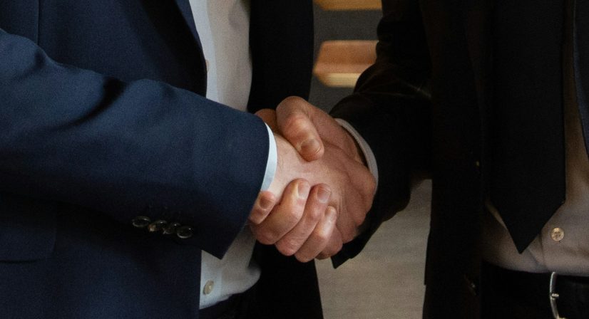 Aperto de mãos selando acordo comercial entre dois executivos