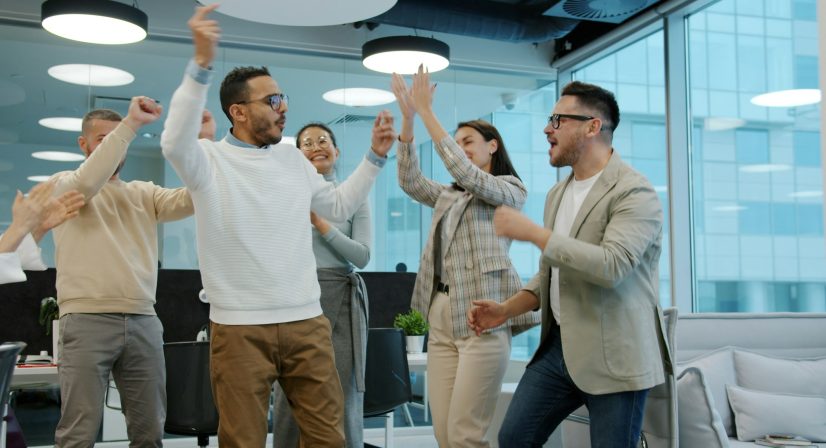 Equipe comemorando resultado de sucesso no escritório