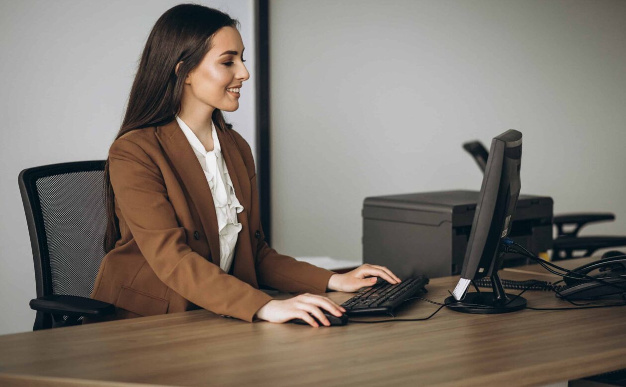 Profissional utilizando computador com CRM e SFA para apoiar a gestão de vendas