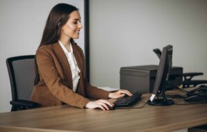 Profissional utilizando computador com CRM e SFA para apoiar a gestão de vendas
