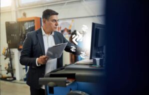 Um gestor de vendas analisa CRM para indústrias em computador.